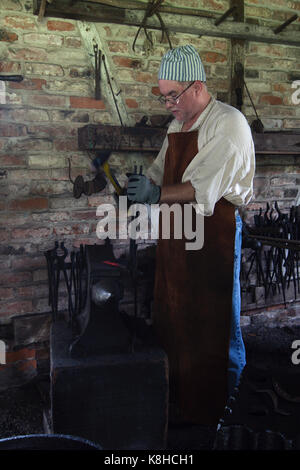 Baton Rouge, Louisiana, USA - 2016: A blacksmith at LSU Rural Life Museum, an outdoor museum of Louisiana history. Stock Photo