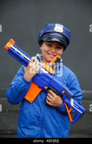 10-year-old boy wearing a policeman's cap and holding a toy gun. france. Stock Photo