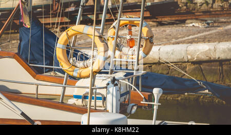 BILBAO, SPAIN - July 18, 2016 : close up on sun-bleached rescue buoys hanging on a boat in the marina Stock Photo