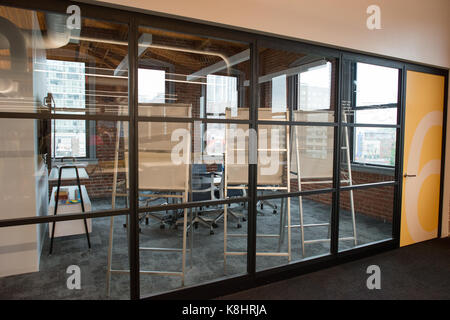 Trendy modern open concept loft office space with big windows, natural light and a layout to encourage collaboration, creativity and innovation Stock Photo