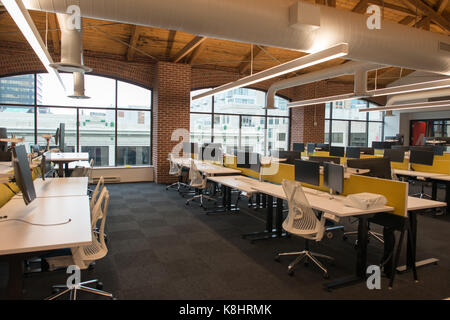 Trendy modern open concept loft office space with big windows, natural light and a layout to encourage collaboration, creativity and innovation Stock Photo