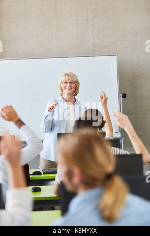 Students in school class know the answer and lift hands Stock Photo