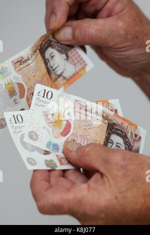 A man pictured holding a new ten pound note at his home in Chichester, West Sussex, UK. Stock Photo