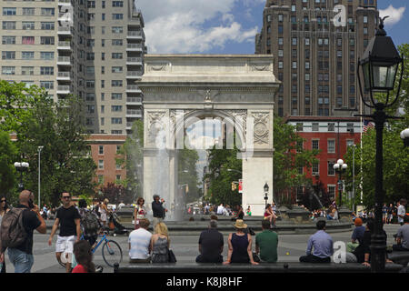 New York, NY, USA - June 1, 2017: Tourists and New York locals alike enjoy a sunny day in Washington Square Park Stock Photo