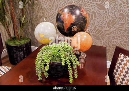 Two chairs by a table decorated with globes in a sitting room. Stock Photo