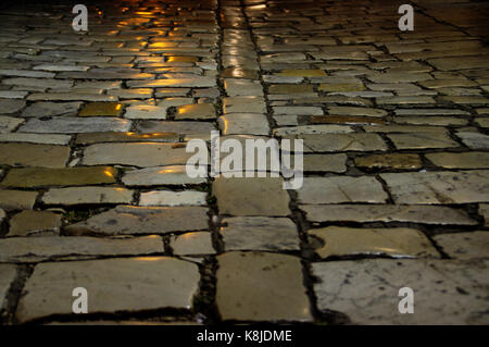 Vintage paving stone road. Perspective view of cobbled street. Stock Photo