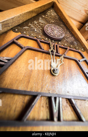 Old wooden wall clock with a cuckoo close up. Stock Photo