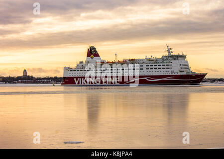 Viking Line cruise arriving at the port of Helsinki, Finland, at dawn in winter, with the Fortress of Suomenlinna in the background Stock Photo