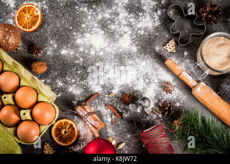 Christmas, New Year holiday cooking background. Ingredients, spices, dried oranges and baking molds, Christmas decorations (balls, fir-tree branch, co Stock Photo