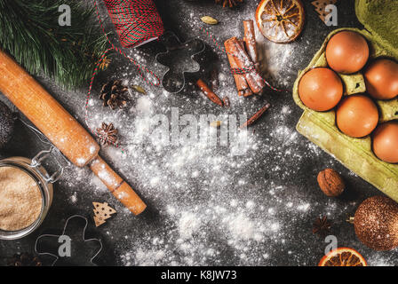 Christmas, New Year holiday cooking background. Ingredients, spices, dried oranges and baking molds, Christmas decorations (balls, fir-tree branch, co Stock Photo