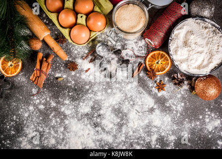 Christmas, New Year holiday cooking background. Ingredients, spices, dried oranges and baking molds, Christmas decorations (balls, fir-tree branch, co Stock Photo