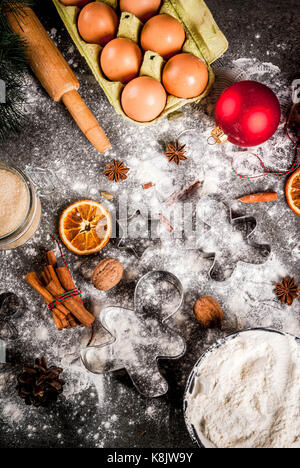 Christmas, New Year holiday cooking background. Ingredients, spices, dried oranges and baking molds, Christmas decorations (balls, fir-tree branch, co Stock Photo