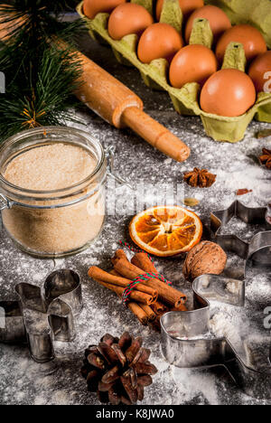 Christmas, New Year holiday cooking background. Ingredients, spices, dried oranges and baking molds, Christmas decorations (balls, fir-tree branch, co Stock Photo