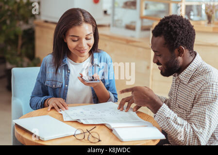 Pleasant woman taking photo of charts Stock Photo