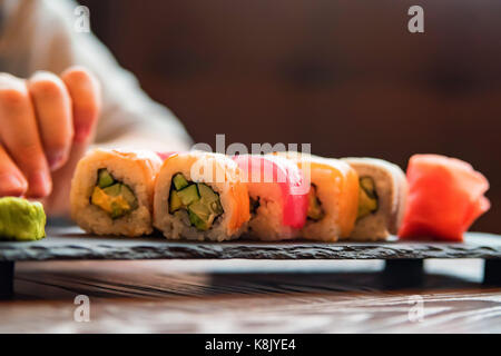 Eating sushi rainbow roll in restaurant