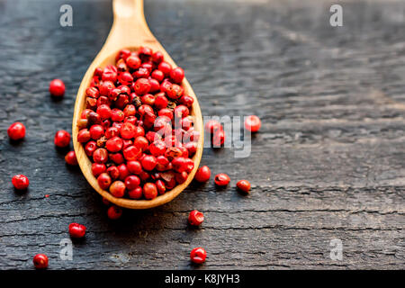 Pink peppercorn in wooden spoon studio shot Stock Photo