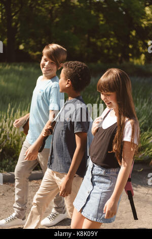 multiethnic teens walking in park Stock Photo