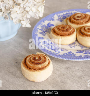 Old fashioned homemade cinnamon buns on an old plate. Stock Photo