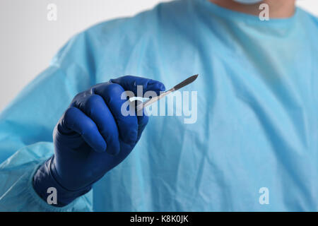 Man surgeon holds a scalpel Stock Photo