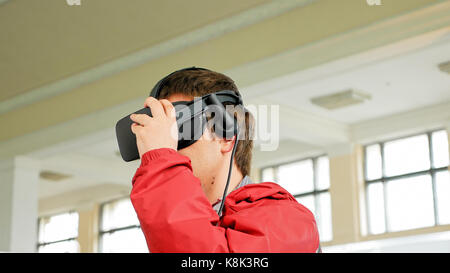 Young man in VR headset playing virtual game Stock Photo