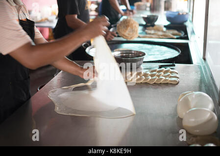 preparing,frying,cooking or making the malaysian flatbread,also known as roti canai.famous and popular in asia,especially malaysia.breakfast,lunch and Stock Photo