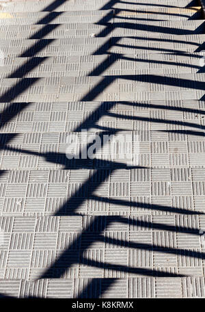 Concrete steps of the stairs, photographed close-up from above. on the surface of the stairs there are shadows from the railing near the building Stock Photo