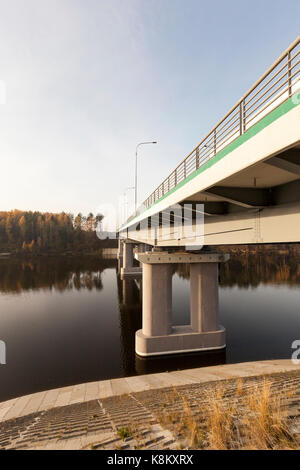 new bridge across the river, made of concrete and metal. The photo was taken close-up with the bottom of the structure, visible columns and the river. Stock Photo