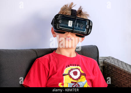 Close-up of young boy wearing Oculus Gear VR headset, virtual reality (VR) equipment with Samsung phone.