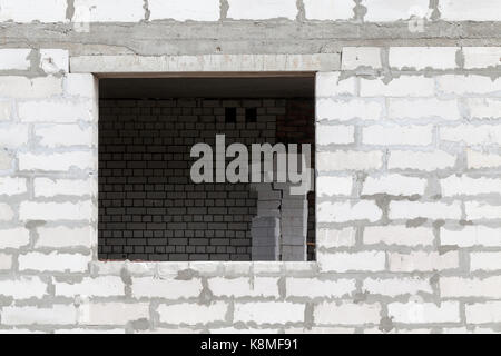 wall of the building is made of gas silicate blocks. Photo close-up. In the wall there is a window opening in which one can see a wall of white brick  Stock Photo