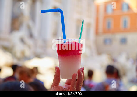 Two-colored ice dessert granita in hand in the background Trevi fountain Stock Photo