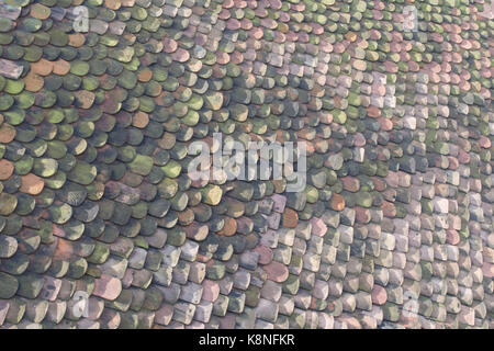 Photo taken from a church tower of an adjoining buildings roof tiles displaying a multitude of colours Stock Photo