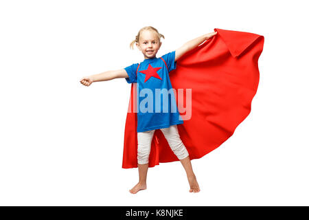 Very excited little girl dressed like hero jumping isolated on white background. Stock Photo