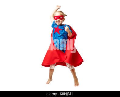 Very excited little girl dressed like hero jumping isolated on white background. Stock Photo