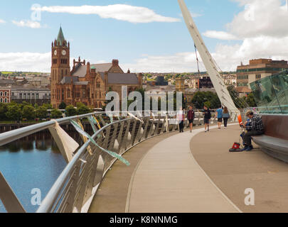 A view across the River Foyle from the iconic Peace Bridge to the famous Londonderry City Guild Hall Stock Photo