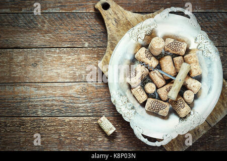 Wine corks and corkscrew on wooden table in a metal bowl Stock Photo