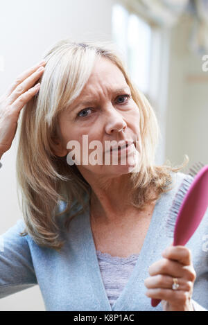 Mature Woman With Brush Corncerned About Hair Loss Stock Photo