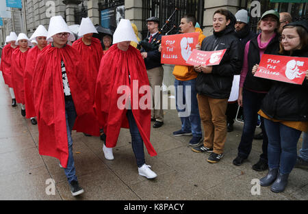 Dublin, Ireland. 20th September 2017.  A group of ‘Handmaids’ walk past an anti-abortion protest outside the gates of the Irish Parliament, Leinster House, in Dublin, today as the Oireachtas Committee on the 8th Amendment starts its public sessions. The protesters are calling for full bodily autonomy for pregnant women. The protest was organised by ROSA (Reproductive rights, against Oppression, Sexism and Austerity).  Credit : Laura Hutton/Alamy Live News. Stock Photo