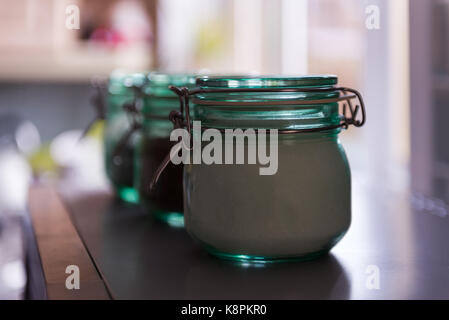 Kitchen jars with sugar coffee and teabags. The jars are taken in close and the first in focus while the other two are in bokeh. Taken in natural ligh Stock Photo