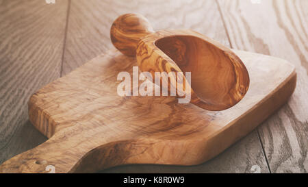 composition with olive wood scoop on top of oak table Stock Photo