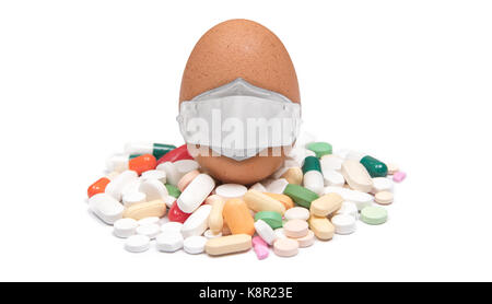 Masked brown chicken egg on variety pills and capsules. Isolated on white background. Stock Photo