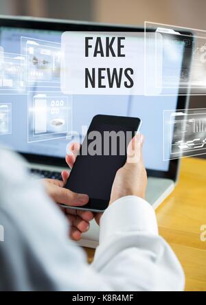 Digital composite of Holding phone with Fake news text and interface Stock Photo