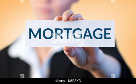 Close up of businesswoman holding blank card against orange vignette Stock Photo