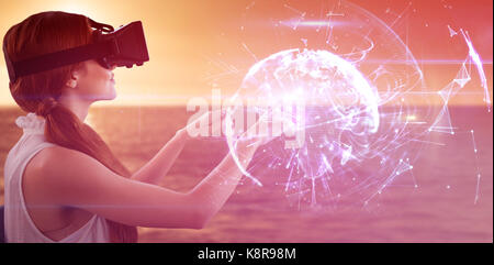 Side view of young woman gesturing while using virtual reality simulator against global technology background in purple Stock Photo