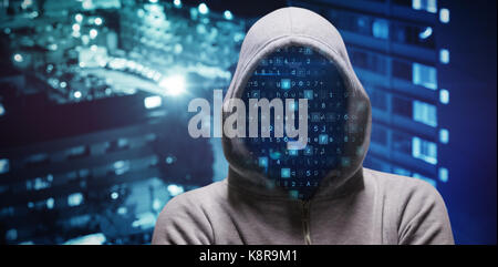 Hacker standing with arms crossed  against high angle view of crowded buildings in city Stock Photo