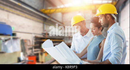 Architects discussing over blueprint against workshop Stock Photo