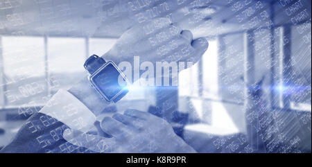 Cropped hand of businessman wearing smart watch against stocks and shares Stock Photo