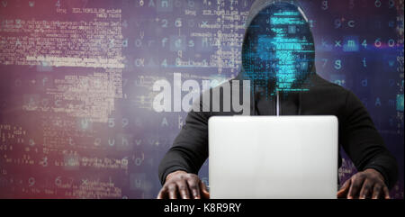 Male hacker with laptop on table  against pink and purple colors background Stock Photo