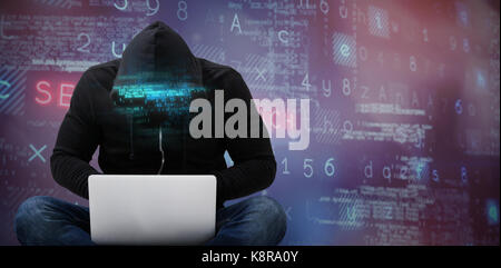 Male hacker using laptop against purple and pink background Stock Photo