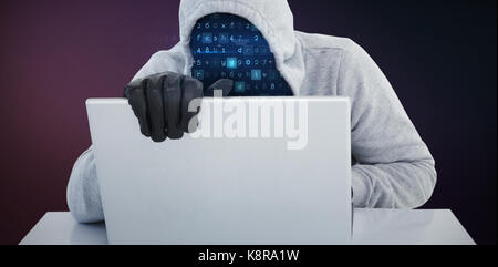 Hiker in gray hoodie and gloves using laptop against pink and purple colors background Stock Photo