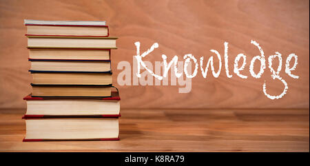 Knowledge text against white background against hardcover books stack Stock Photo